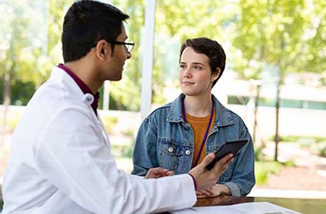 A male proton therapy physician discussing proton therapy with a female patient.