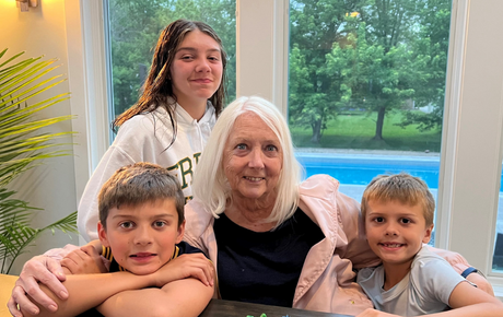 Proton patient Barbara smiling with her three grandchildren, two young boys and one young girl.