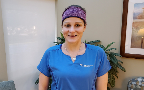 Laura Lundstrom, RN, smiling in her blue nursing scrubs.